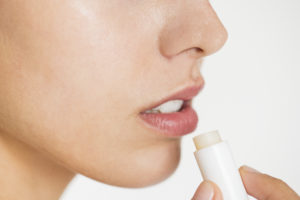 women applying lip balm