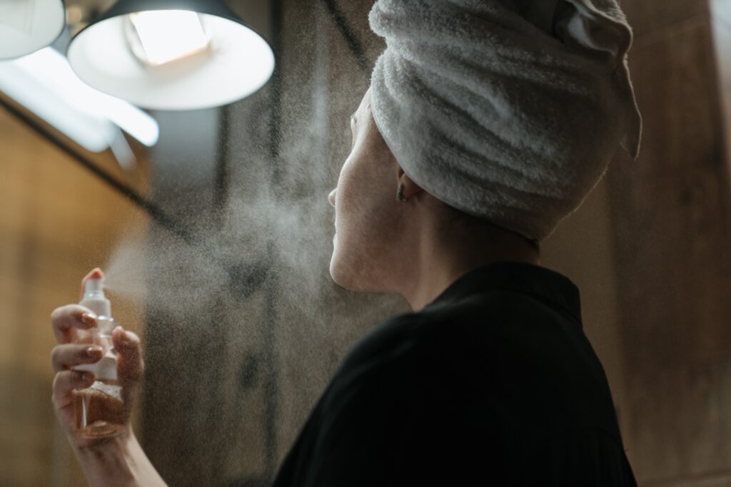 women applying makeup setting spray